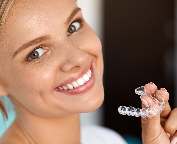 Woman placing Invisalign clear braces tray