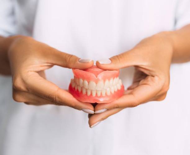 Lady presents viewer with dentures