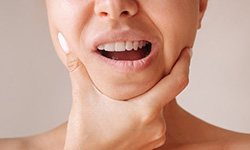 Lady considers the fit of her new dentures