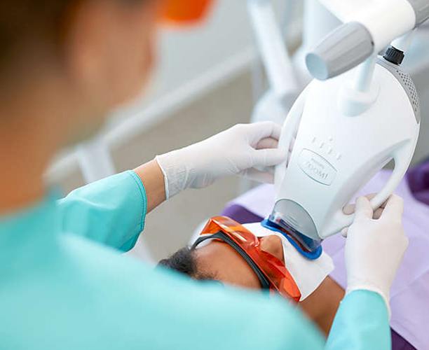 Patient receiving zoom teeth whitening in the dental office