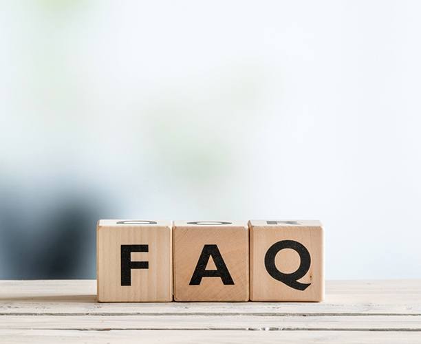 Wooden letter blocks spelling FAQ on white ledge 
