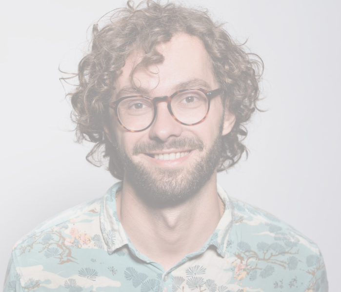 Smiling man with curly hair and glasses