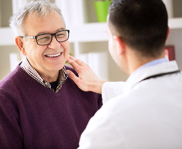 dentist putting his hand on a patient’s shoulder 