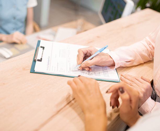 Patient filling out in office dental membership plan application forms