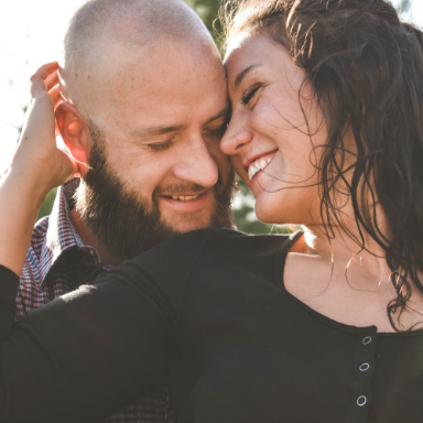 Man and woman smiling with their heads together