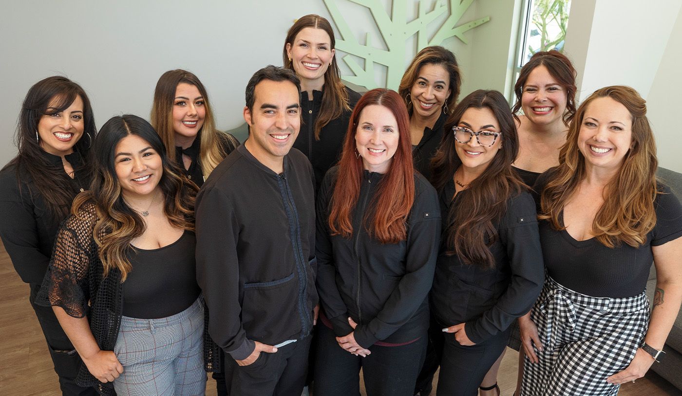 Las Cruces dental team members around their neighborhood entry sign