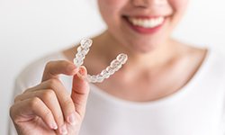 person holding an Invisalign aligner 