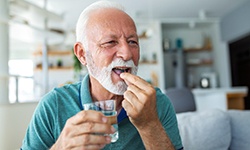 Senior man preparing to swallow a pill
