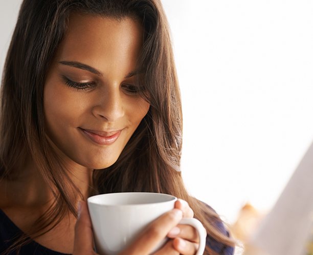 Woman drinking coffee which can stain teeth
