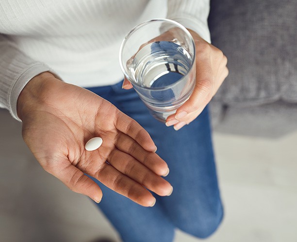 Aerial view of white pill in patient's hand