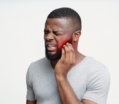 Man in need of emergency dentistry holding jaw in pain