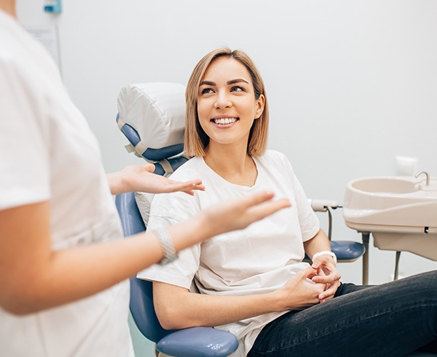 Woman smiling at dentist during dental checkup and teeth cleaning visit