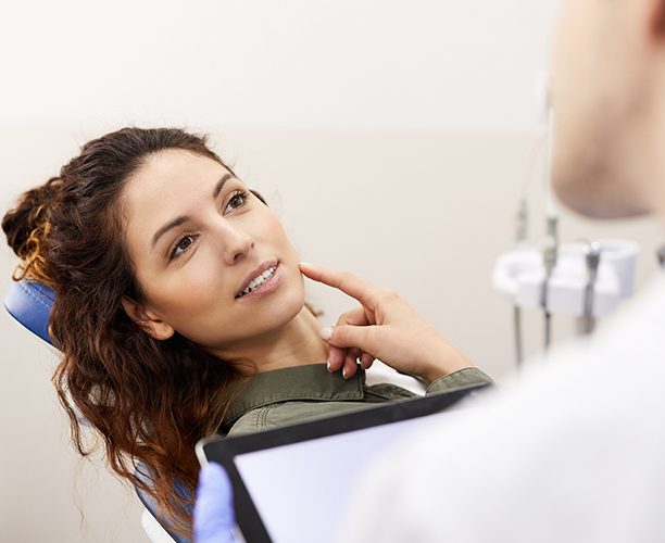 Patient pointing to jaw during comprehensive dental checkup