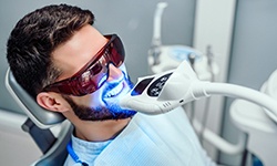 Man in dental chair undergoing teeth whitening treatment