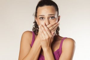 woman embarrassed covering her mouth