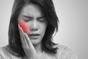 Woman holding mouth in pain