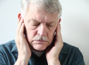 older man holding jaws in pain