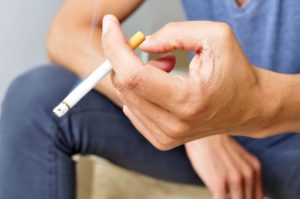 Man holding a cigarette after dentist in Las Cruces.