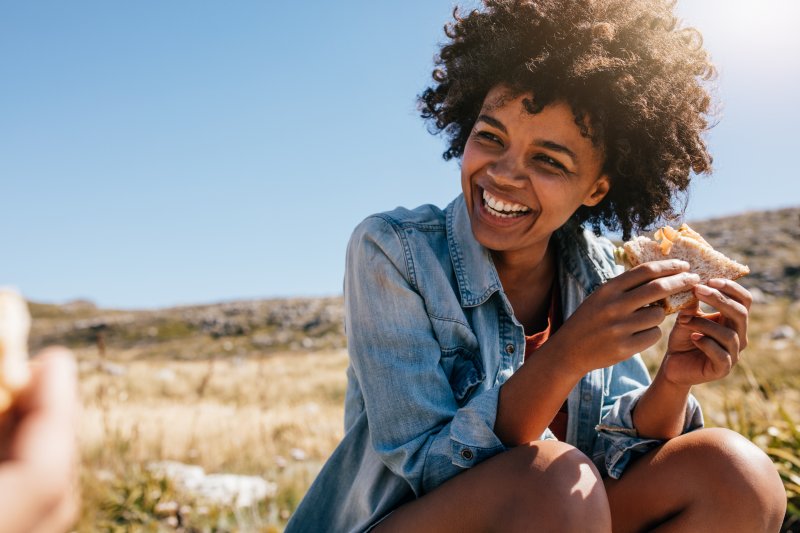 girl smiling while eating outside during summer