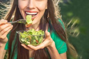 woman eating foods that benefit your oral health