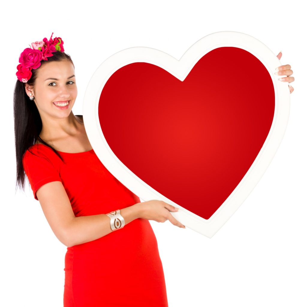 person smiling and holding large paper heart