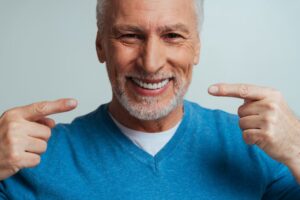 Senior with dentures smiling.